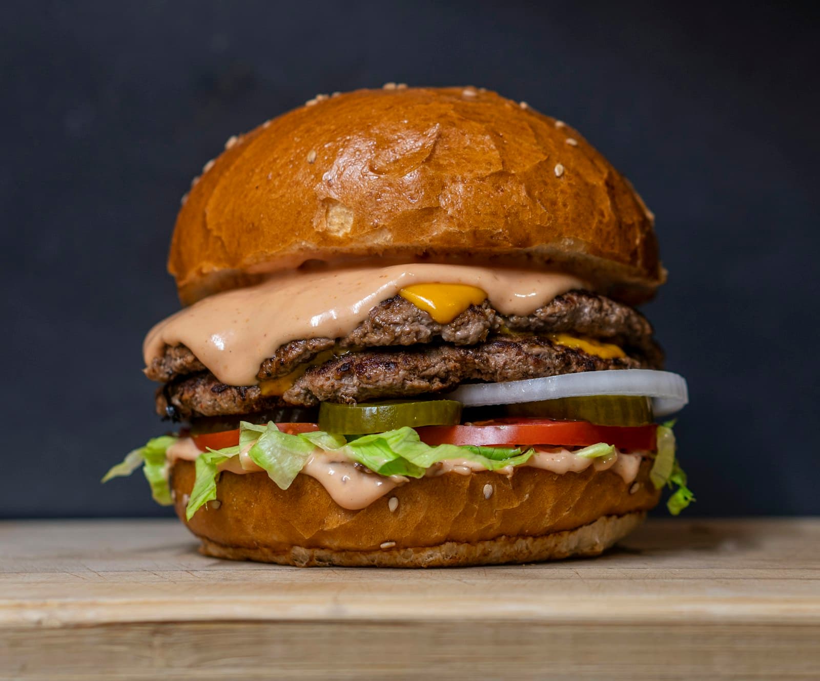Cheeseburger with lettuce, tomato and pickles on a toasted bun