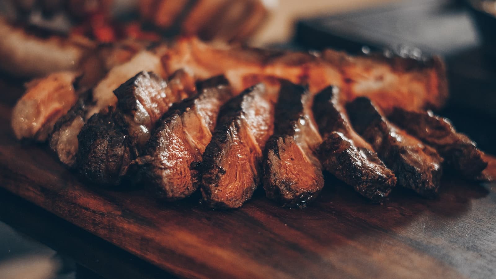 Flame-grilled steak, sliced on a wooden board