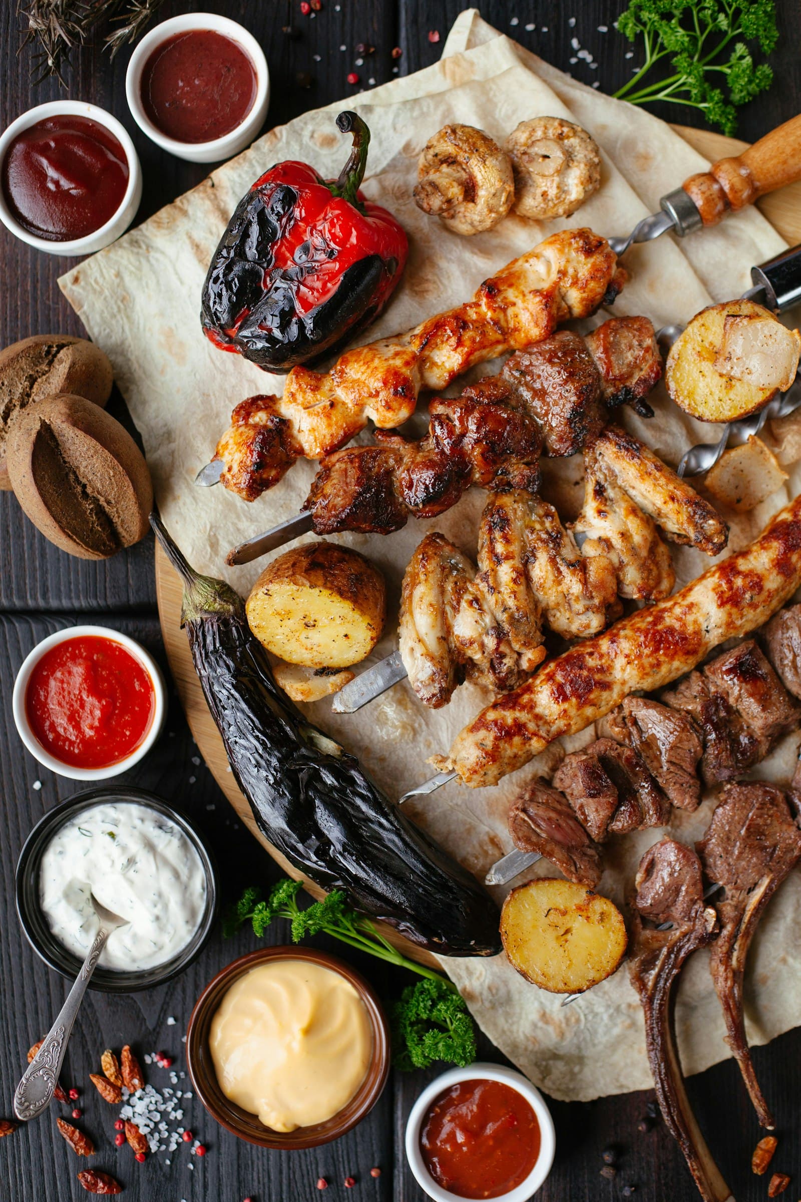 Mixed grill board with skewers of chicken and beef, chouriço, wings and grilled peppers